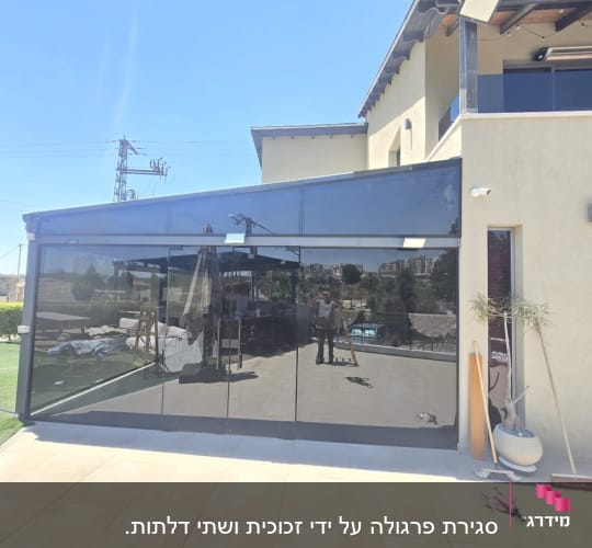 מבנה עם חלונות זכוכית גדולים וחצר